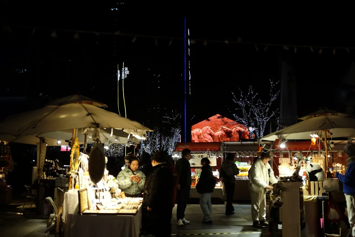 Night-market stalls under city towers.